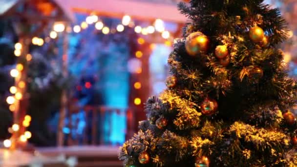 Árbol de Navidad con pelotas frente a casa borrosa — Vídeos de Stock