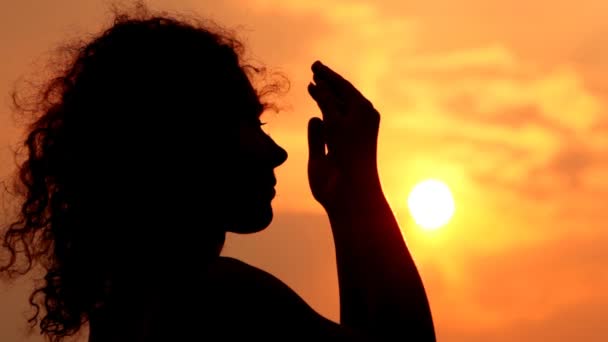 Mujer contra el cielo y el sol abre la cara manos y cierra — Vídeos de Stock