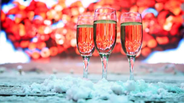 Três copos de champanhe ou branco suporte de vinho neve polvilhada — Vídeo de Stock