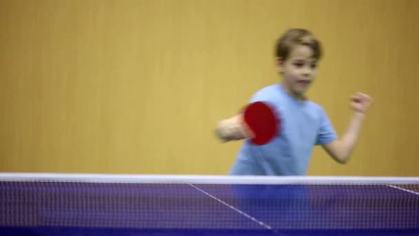 Kleiner Junge im blauen Hemd spielt Tischtennis — Stockvideo