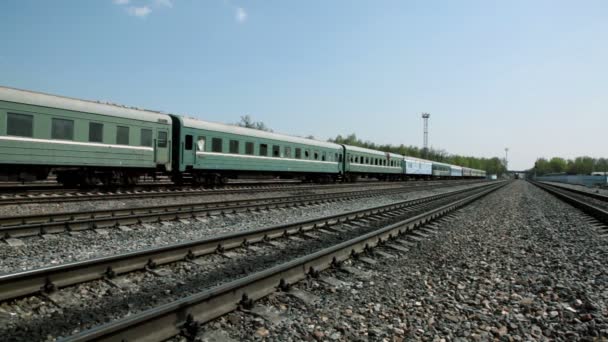Short train passes by on railway, traffic on bridge far — Stock Video