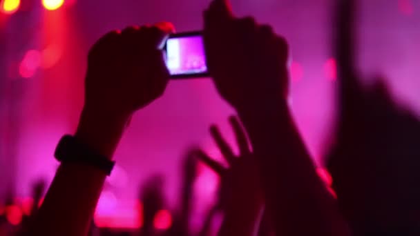 Händerna hålla kamera med digital display bland människor på rave party — Stockvideo