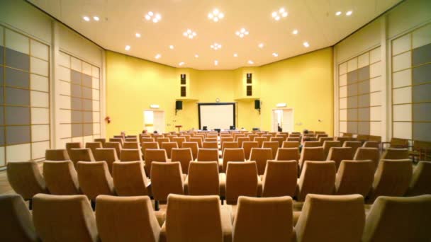 Nur wenige Menschen sitzen im Konferenzsaal — Stockvideo