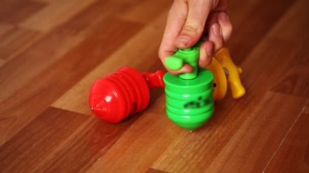 Красочные игрушечные топы с яркими огнями ролл на столе — стоковое видео