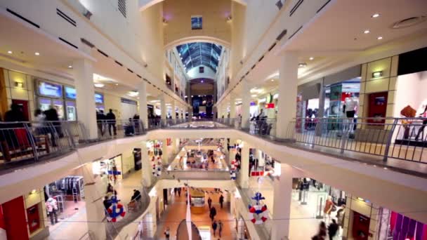 People walk along boutiques on multiple floors shopping center Atrium — Stok video