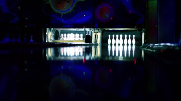 Machine instellen van tenpins op bowling verlicht in donkere club en ballen roll beat kegelen — Stockvideo