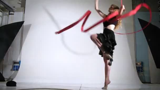 Дівчина-гімнастка зі стрічкою для фотографа в студії — стокове відео