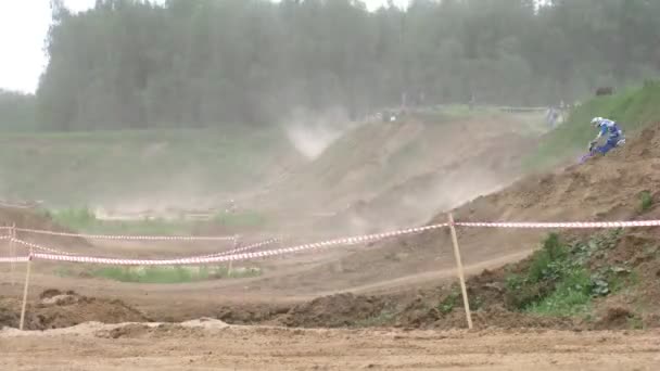 Les coureurs cyclistes passent le parcours de course creux devant une clôture légère 