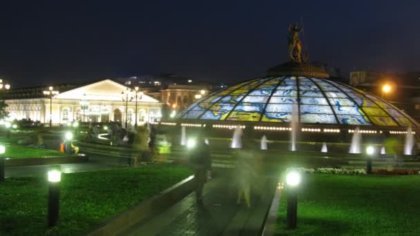 Mensen gaan op het manezhnaja-plein waar er fonteinen en lantaarns zijn — Stockvideo