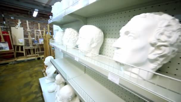 Several sculpture heads are on shelves in store — Stock Video