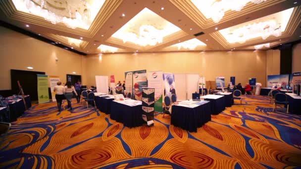 Várias mulheres caminham dentro da sala de luz com stands e mesas no evento Job Fair no Monarch Center — Vídeo de Stock