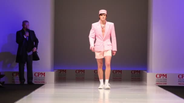 Мужчина в розовом летнем костюме от Славы Зайцева ходит по подиуму — стоковое видео
