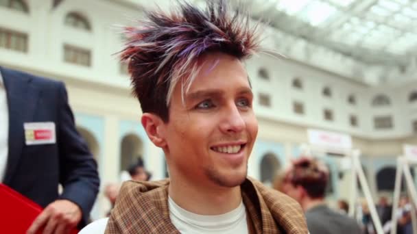 Uśmiechnięty mężczyzna z oryginalna fryzura z fioletowe nici na xvii międzynarodowym świecie festiwal piękna 2010 — Wideo stockowe