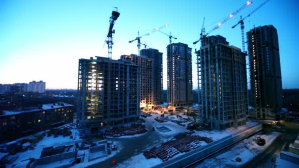 Travailleurs sur le chantier de construction au premier plan du paysage urbain de la zone dortoir — Video