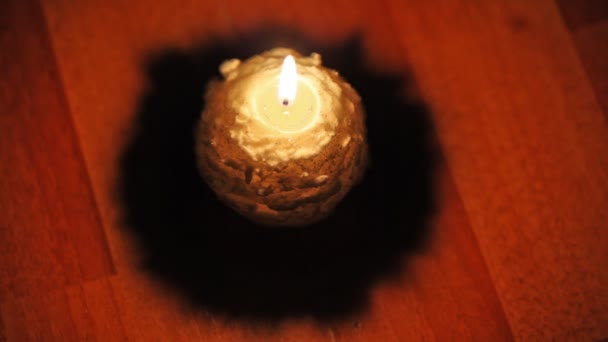 Christmas candle stands on floor and flame sways air — Stock Video