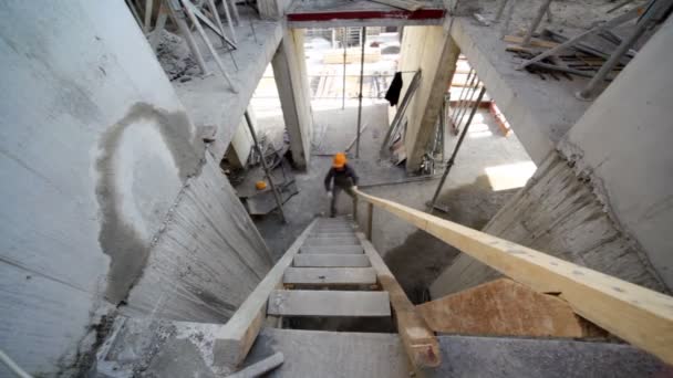 Constructor subir por escaleras de madera en el siguiente piso — Vídeos de Stock