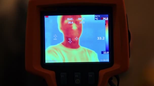 Hand hold thermal image camera, on-screen human face — Stock Video