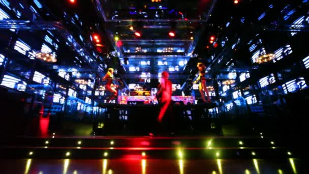 Dos chicas bailando en plataformas en discoteca con paredes de monitores — Vídeo de stock