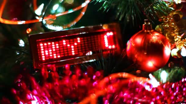 LED display with running line MERRY CHRISTMAS among of blinking garlands and toys on New Year tree — Stock Video