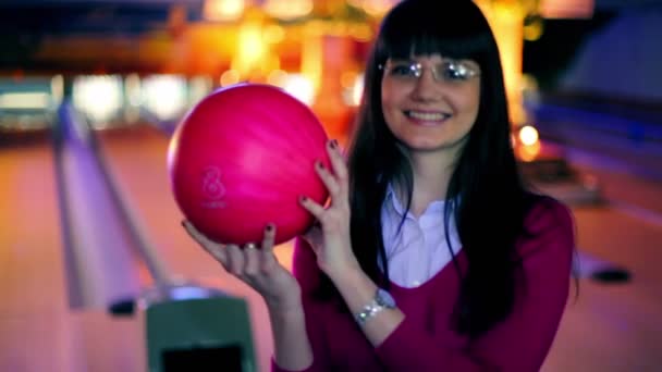 Ragazza tenere palla da bowling e sorridere, e poi lo lancia per battere birilli — Video Stock