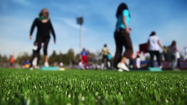 Las mujeres participan en el paso aeróbico en el estadio — Vídeo de stock