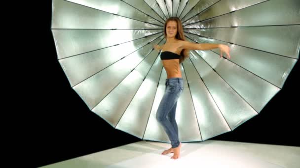 Modelo baila delante del reflector en estudio fotográfico — Vídeo de stock
