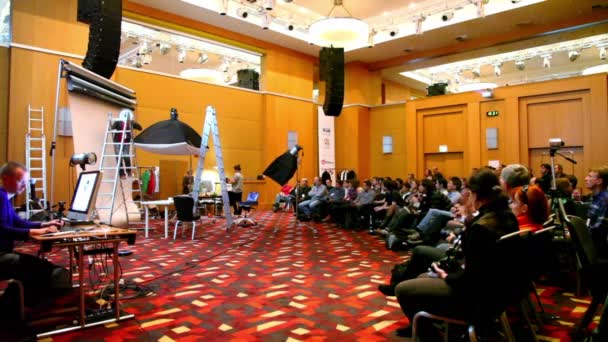 El hombre cuelga el reloj en la lección de fotografía en la conferencia STOCKinRUSSIA 2010 — Vídeos de Stock