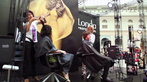 Dois cabeleireiros fazem penteado na master class de Londa — Vídeo de Stock