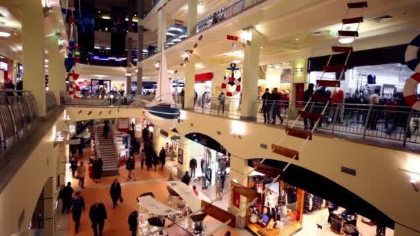 Os clientes caminham ao longo de boutiques em vários andares centro de comércio Atrium em Kurskaya — Vídeo de Stock