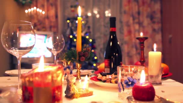 Mesa de comedor de Navidad decorada con botella, vasos, dulces, velas — Vídeos de Stock