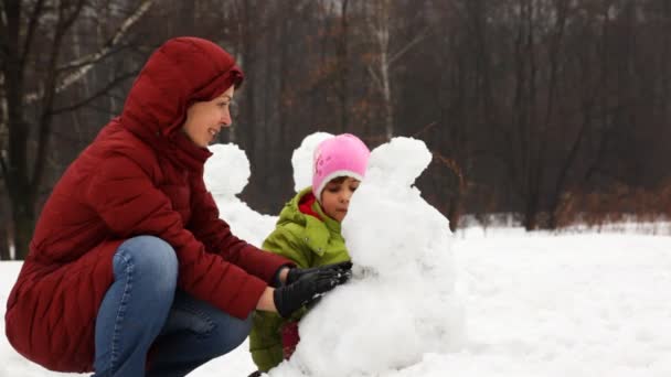 Mor med söta lilla dotter göra snögubbe — Stockvideo