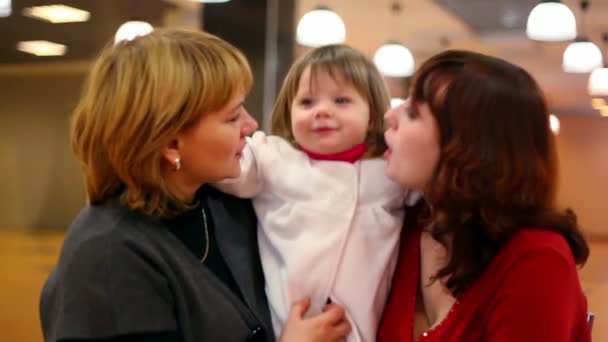 Mormor och mamma kyssa liten flicka inne i cafeterian — Stockvideo