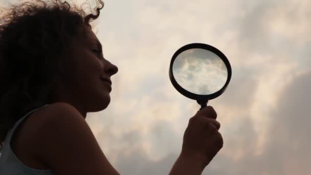 Vrouw houdt van Vergrootglas en langzaam wordt verplaatst naar het — Stockvideo