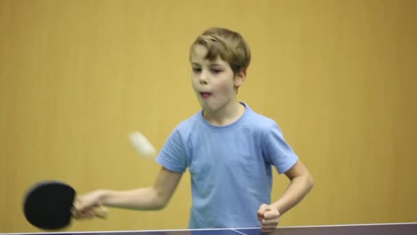 Kleiner Junge im blauen Hemd spielt Tischtennis — Stockvideo