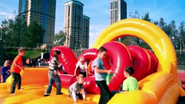 Kids jump on inflated playground at stadium Yantar — Stock Video