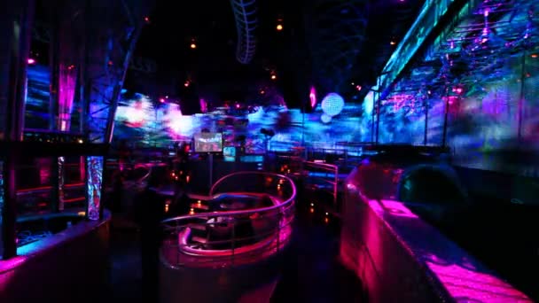 Люди в ночном клубе с ярким светодиодным освещением на стенах — стоковое видео