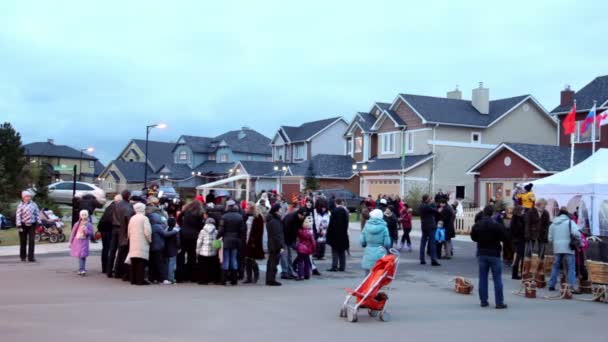 Lot of people walk on street of cottage village at evening — Stock Video