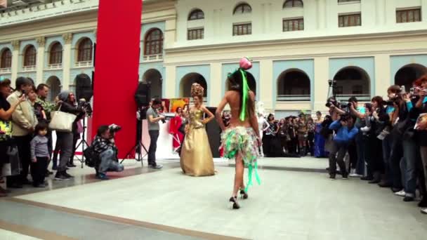 Models in costumes with large uncommon hairdo walk on podium — Stock Video