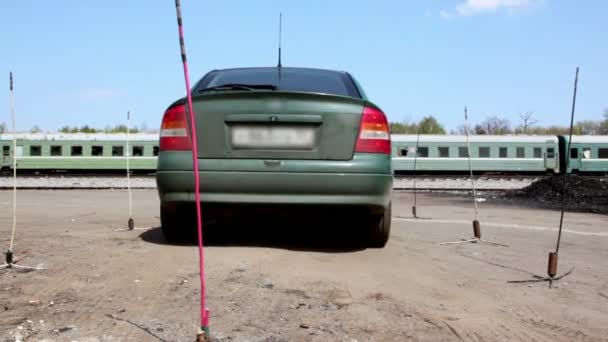 Поездка на машине на уроке вождения, заброшенный поезд стоять на заднем плане — стоковое видео