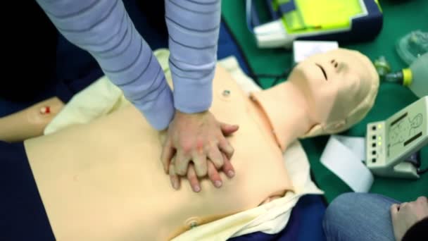 Person trains to do chest compressions on mannequin — Stock Video