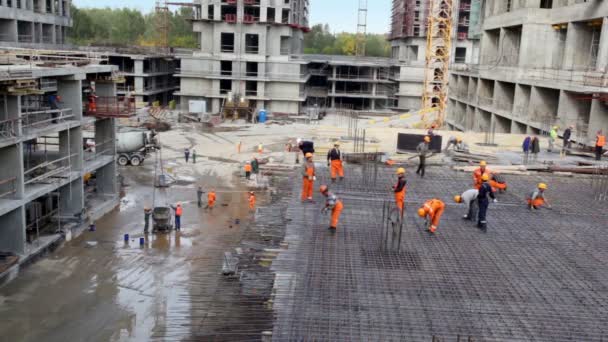 Многие строители в действии на строительной площадке — стоковое видео
