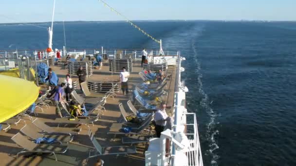 Leden van het cockpitpersoneel stapelen ligbedden op het dek van het cruiseschip — Stockvideo