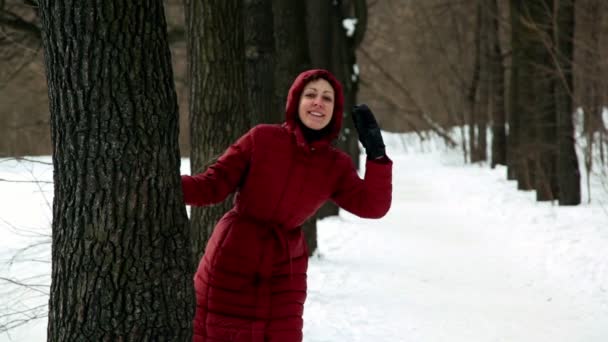 La donna esce da dietro gli alberi e poi si nasconde diverse volte — Video Stock