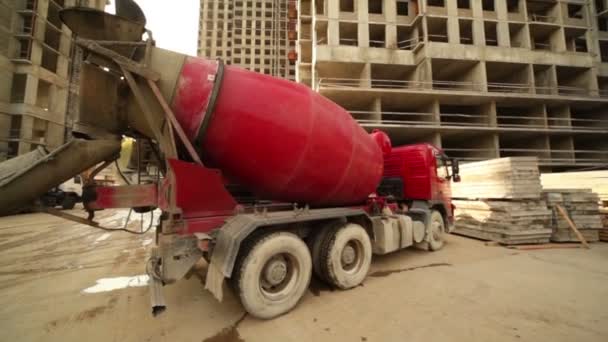 Misturador de concreto ficar perto de edifício inacabado — Vídeo de Stock