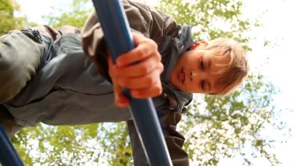 Pojken klättrar på trappan på lekplats — Stockvideo