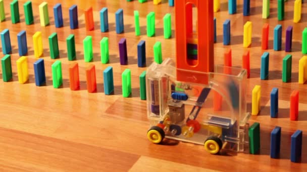 Toy machine moves and put colored domino blocks — Stock Video