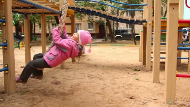 Menina balançar na corda no parque infantil — Vídeo de Stock