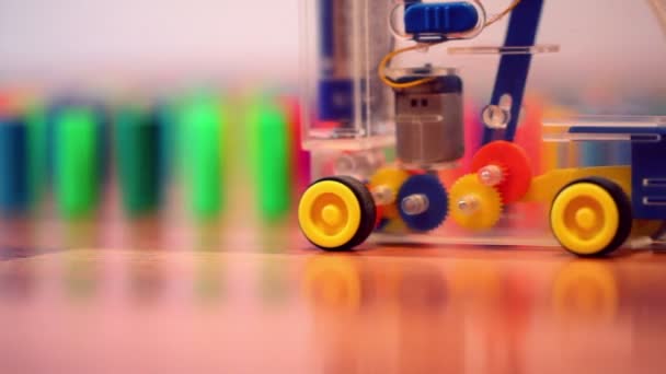 Toy machine moves and put colored domino blocks behind — Stock Video