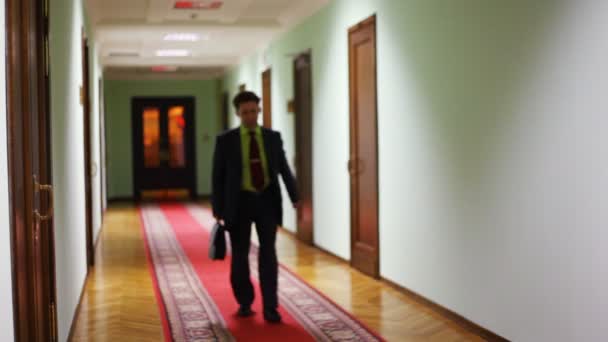 Deputy assistant approaching along corridor — Stock Video