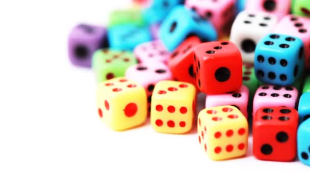 Many colorful dice stacked in pile rotate on white — Stock Video